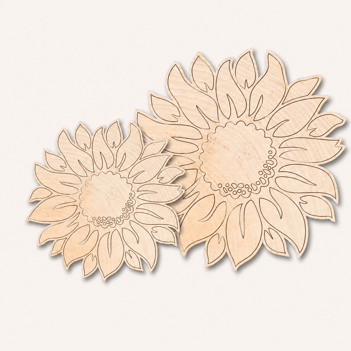 Two laser-cut wooden sunflower shapes in natural light wood, displayed on a clean off-white background.